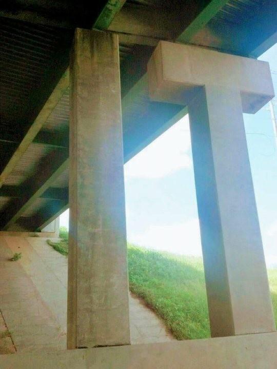 A picture from ground level looking up of a concrete bridge. Two supports are visible in the shape of the letter 'I' and the letter 'T'